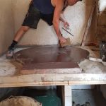 Artisan Feu de Masse en pleine finition d'un poêle de masse