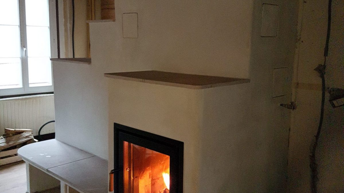 Poêle de masse en cours de finition, feu allumé, Feu de Masse