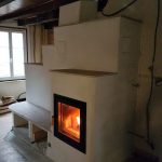 Poêle de masse en cours de finition, feu allumé, Feu de Masse