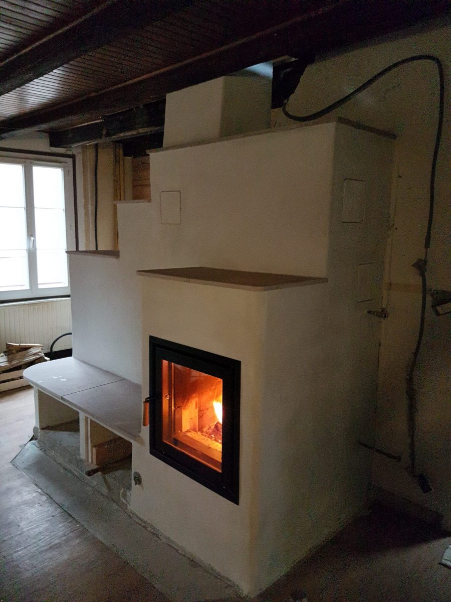 Poêle de masse en cours de finition, feu allumé, Feu de Masse